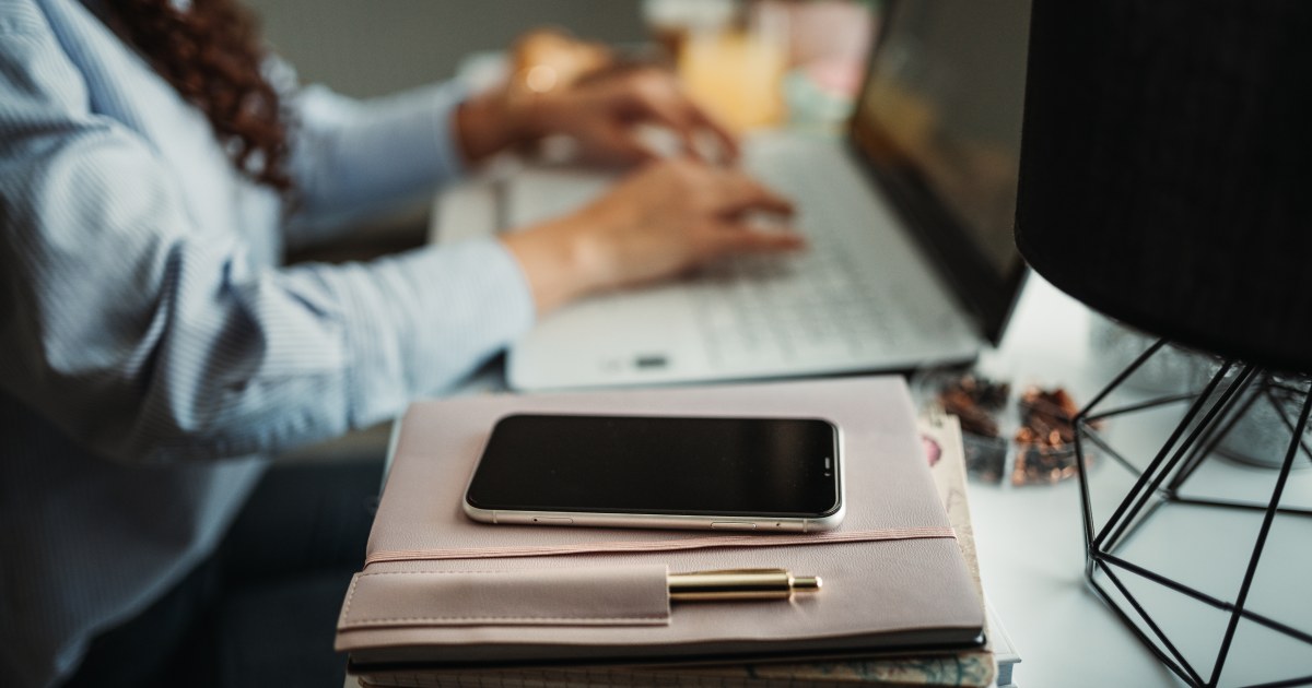 Smartphone sobre agenda junto a laptop para seguridad de correo corporativo en pymes