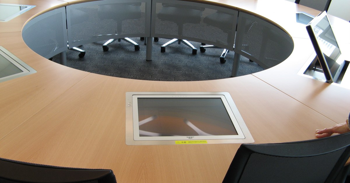 Sala de juntas con mesa redonda para revision de decisiones Sala de juntas con mesa redonda para revisar decisiones y politica de inteligencia artificial en pymes