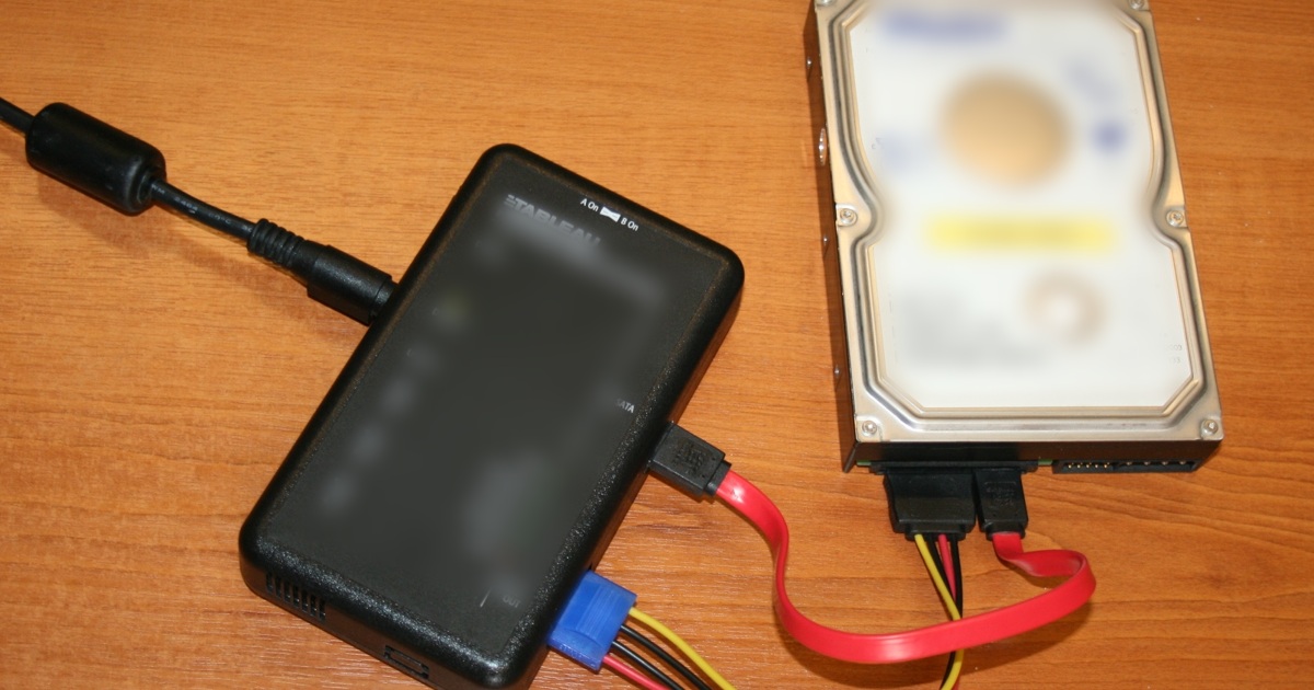 Bloqueador de escritura y disco en mesa de equipo forense Bloqueador de escritura conectado a un disco sobre una mesa de trabajo, contexto ilustrativo de adquisición forense