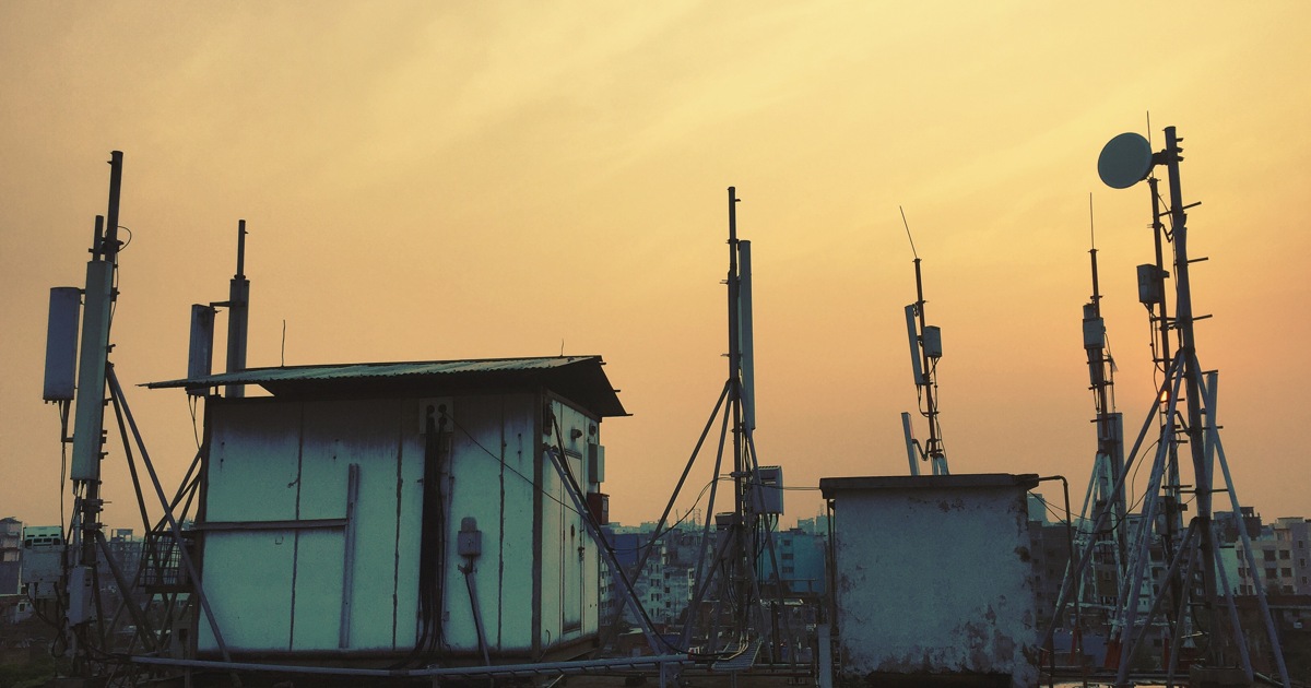Antenas de telecomunicaciones en una azotea al atardecer, fotografía ilustrativa de conectividad