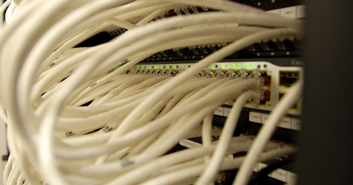 Panel de red con cableado y luces de equipo para representar nube privada, permisos y enlaces compartidos en pymes